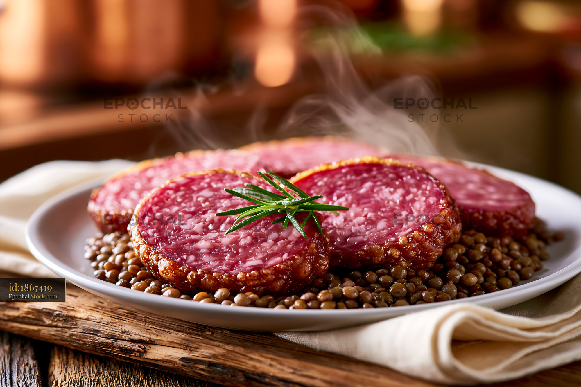 Steaming cotechino modena meat slices on lentils with rosemary - stock photo