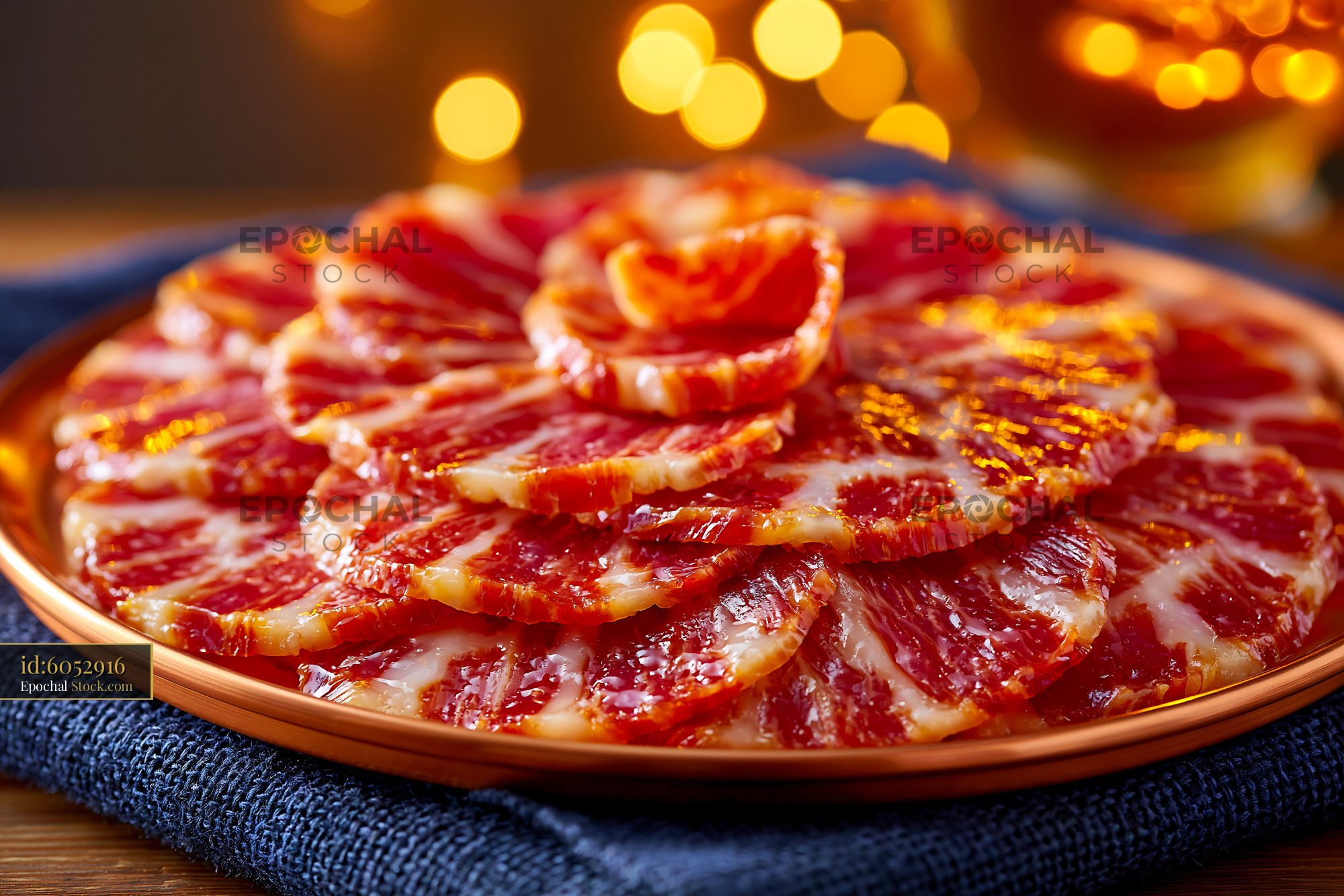 Thinly sliced jamon iberico de bellota meat on a golden plate - stock photo