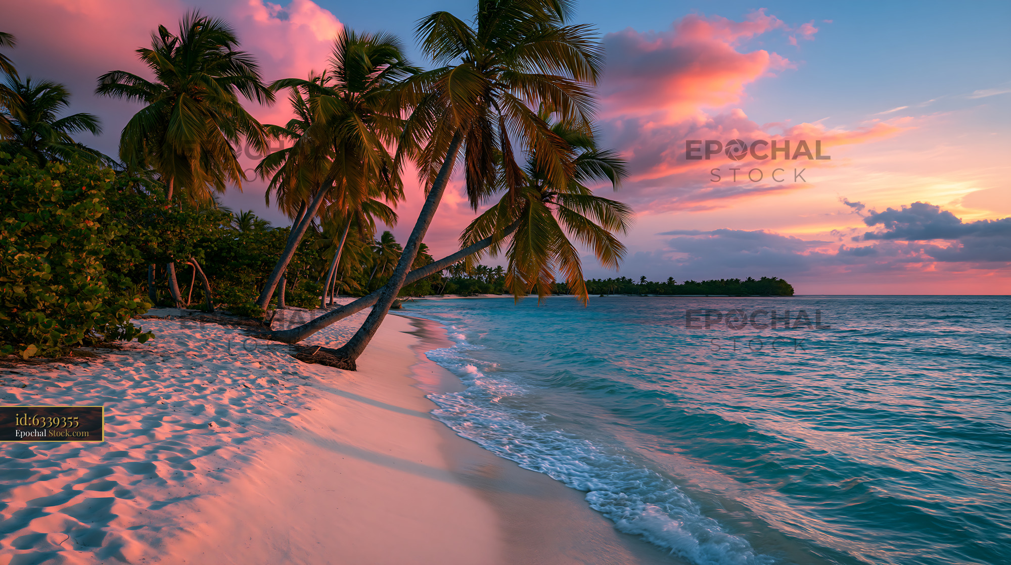 Palm trees on a tropical beach at vibrant pink sunset - stock photo
