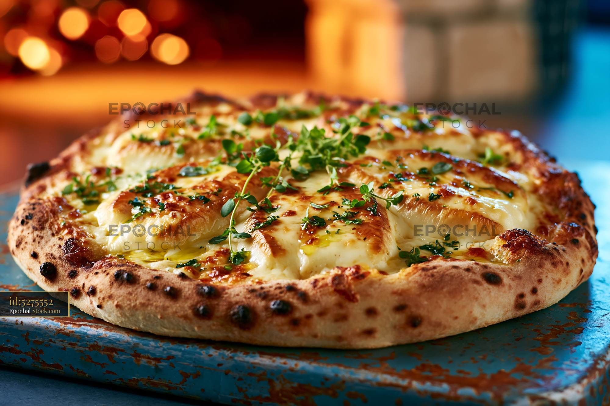 Scamorza affumicata pizza with fresh herbs on a rustic board - stock photo