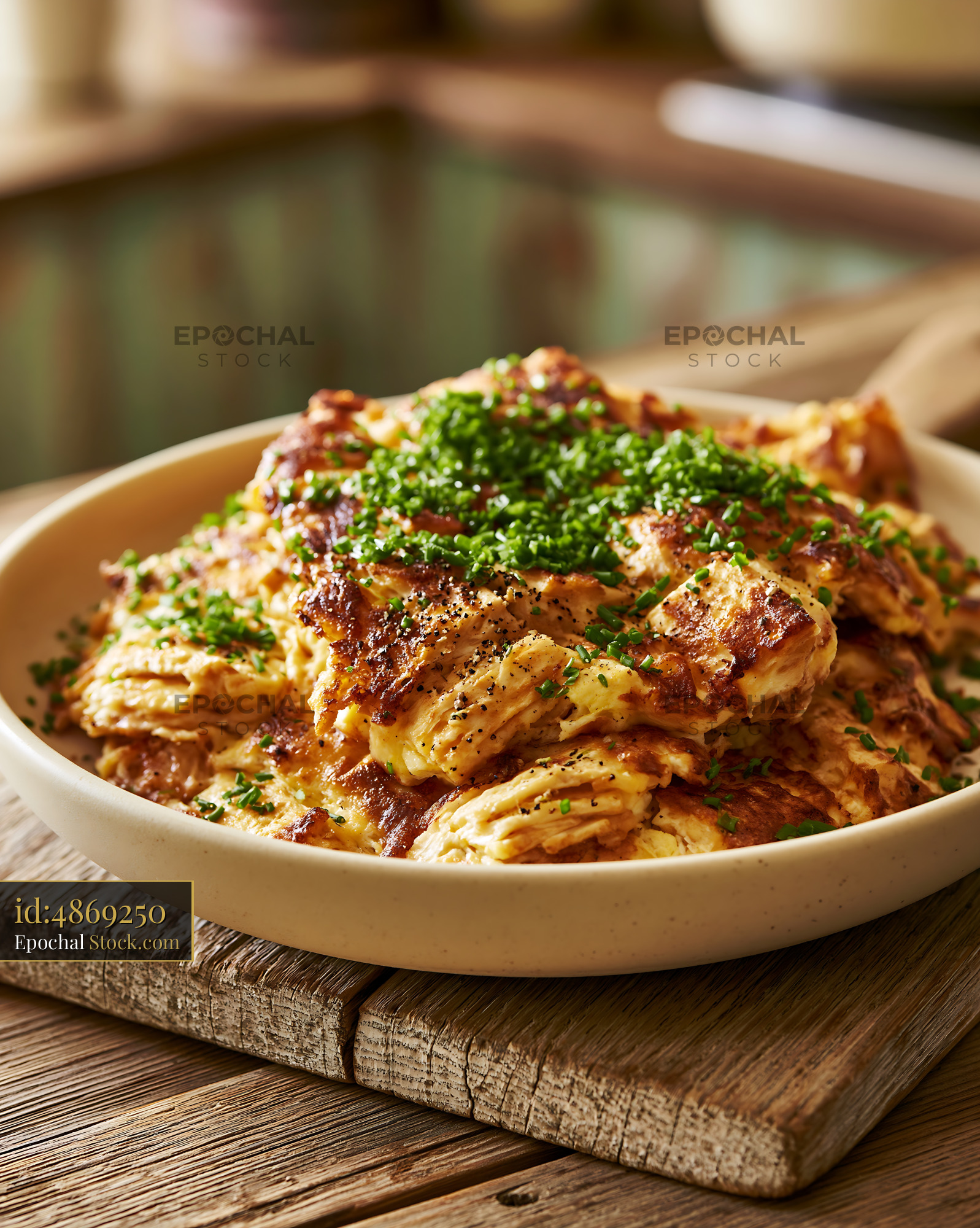 Golden brown matzah brei with fresh chives and pepper in a bowl - stock photo