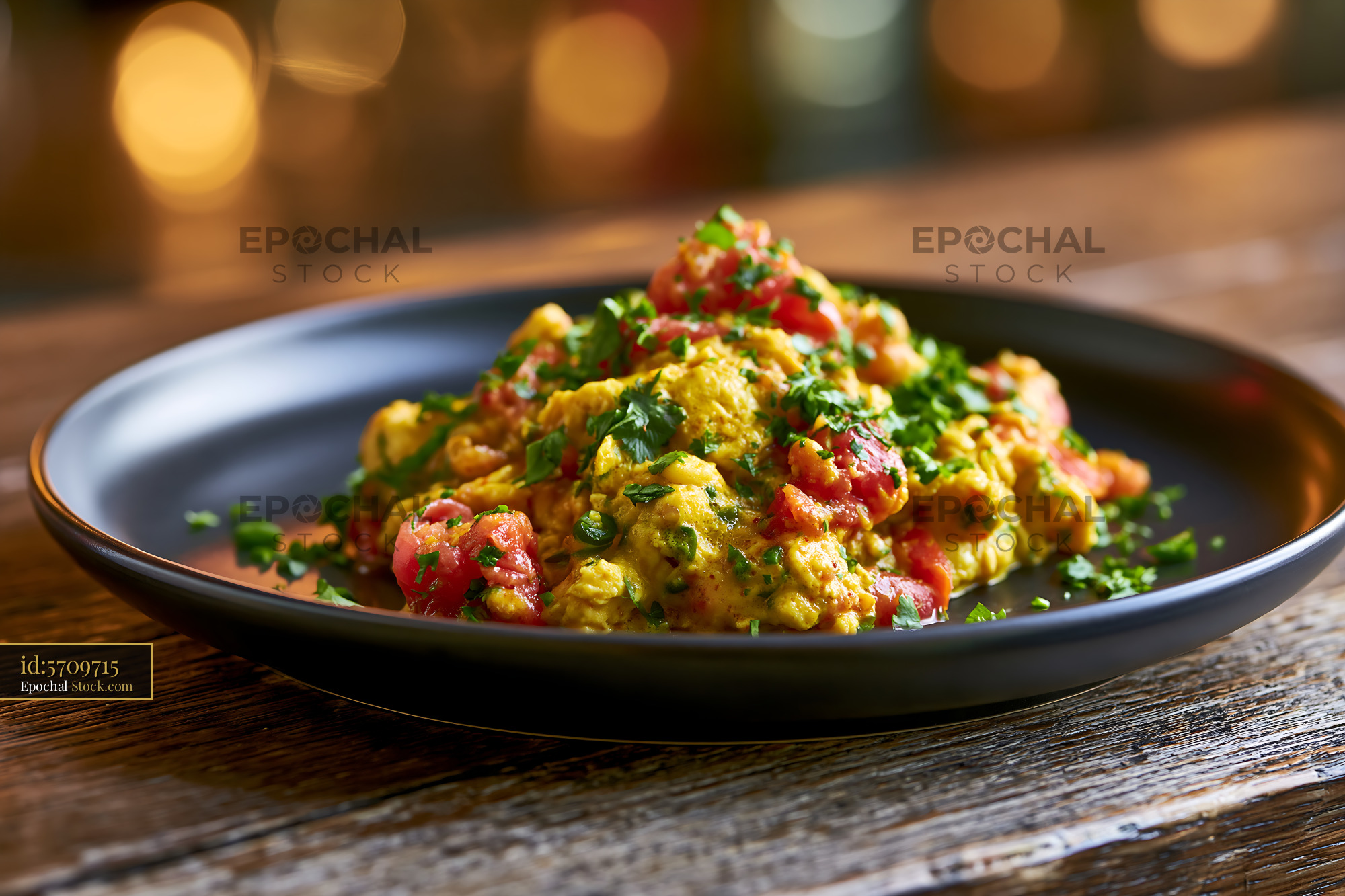 Traditional Parsi akuri egg food with tomatoes and fresh herbs - stock photo