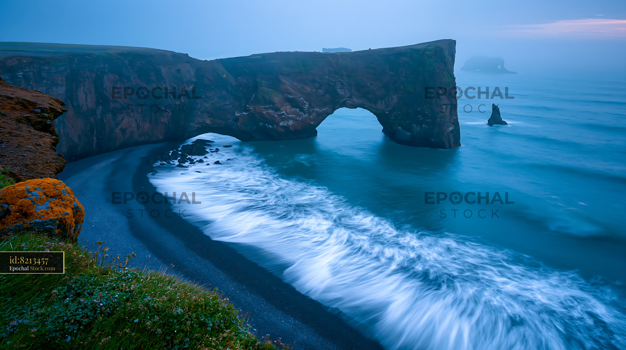 Dramatic rock arch at Dyrholaey on a foggy morning in Iceland - stock photo