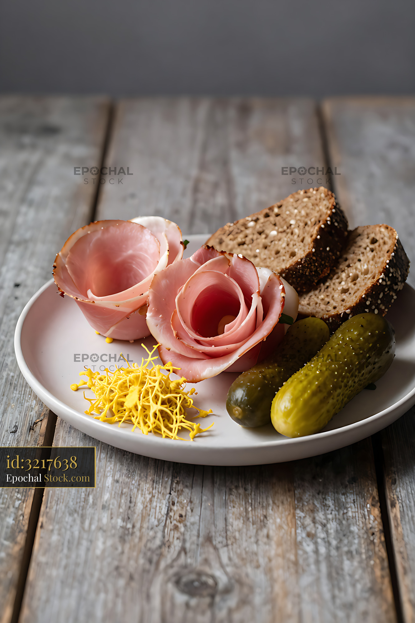 Black Forest ham roses with rye bread and pickles on a rustic table - stock photo