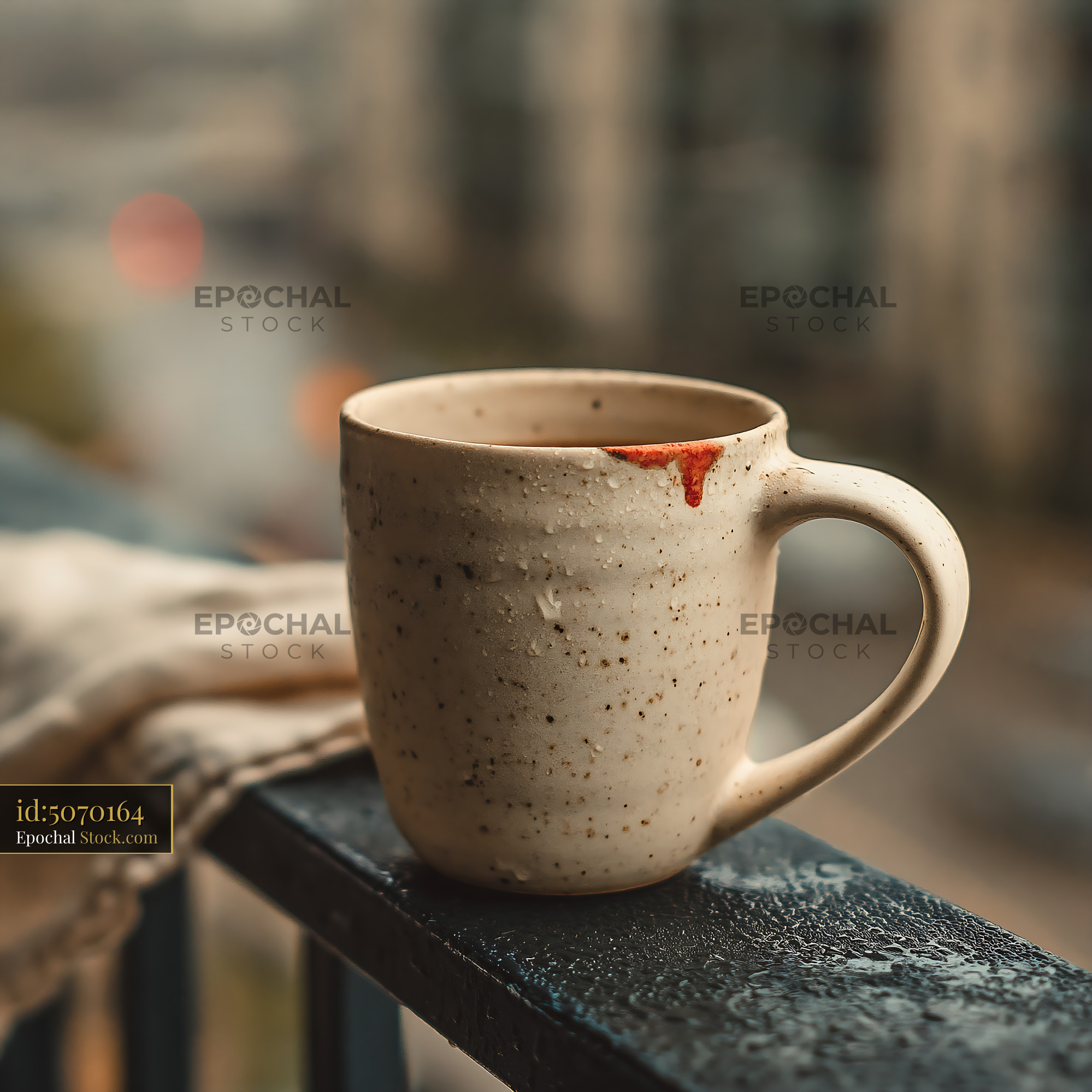 Ceramic coffee cup with lipstick stain on a rainy city balcony - stock photo