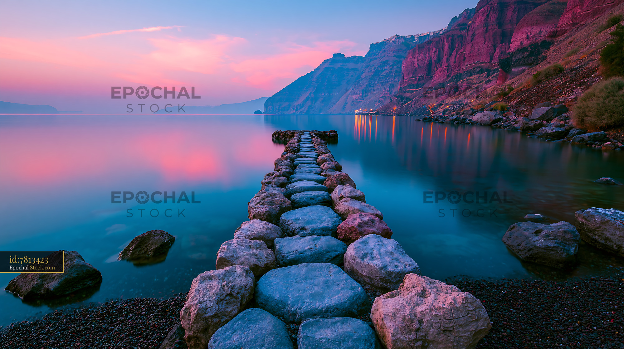Stone path leading into calm ocean at sunset in the Azores - stock photo