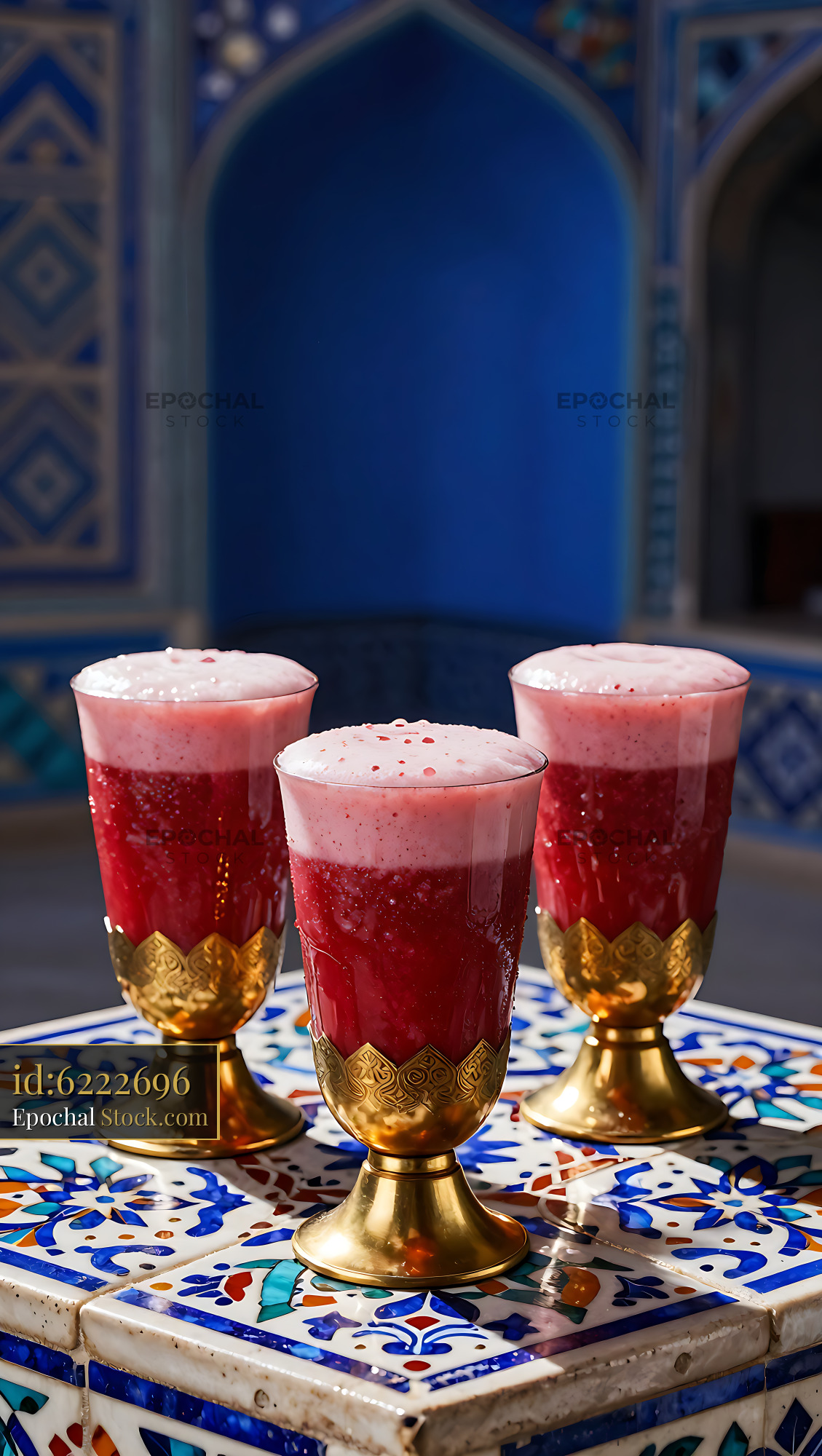 Three Barberry Bloom smoothies in ornate golden glasses on mosaic tabl - stock photo