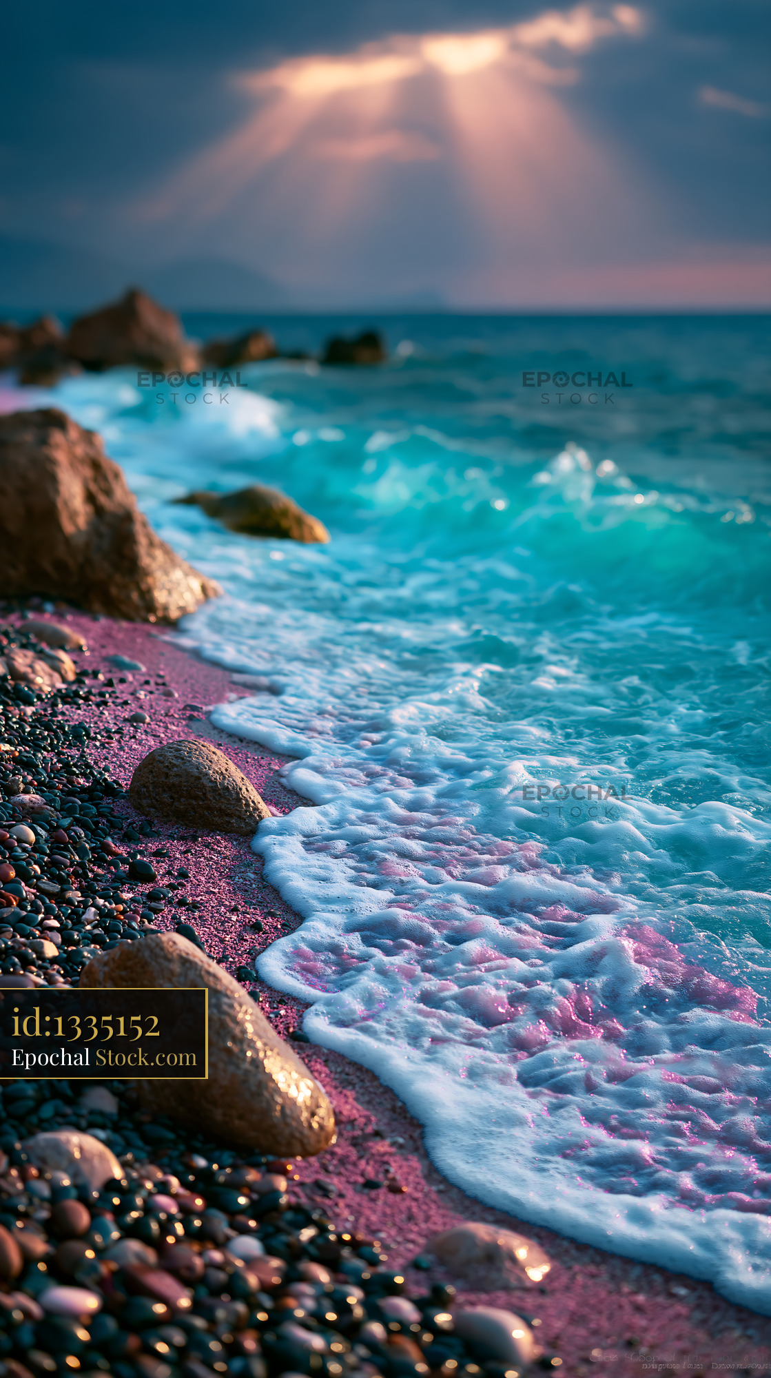 Turquoise ocean waves on pink pebble beach under sunbeams - stock photo