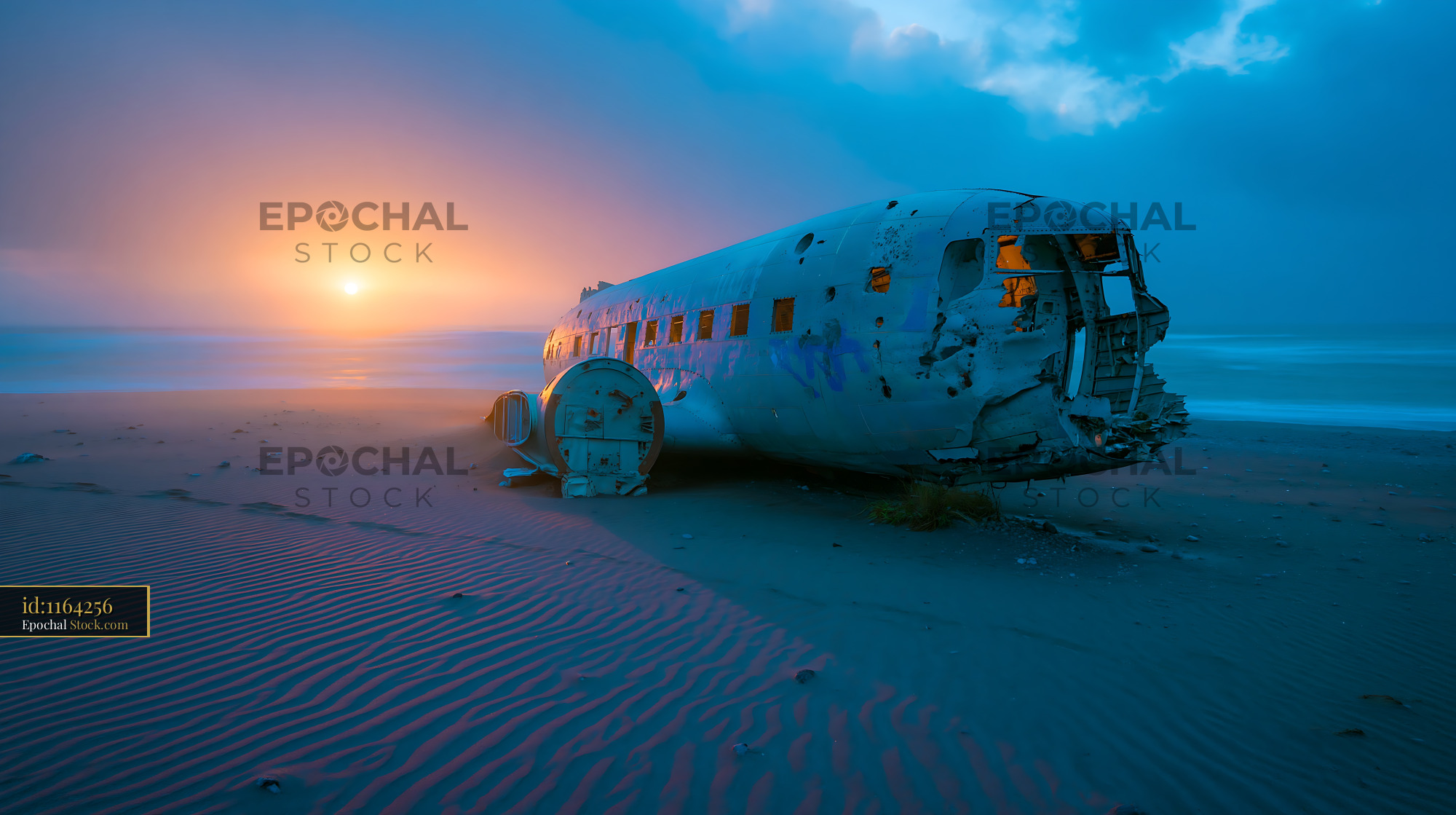 Abandoned airplane wreckage on a sandy beach at sunset - stock photo