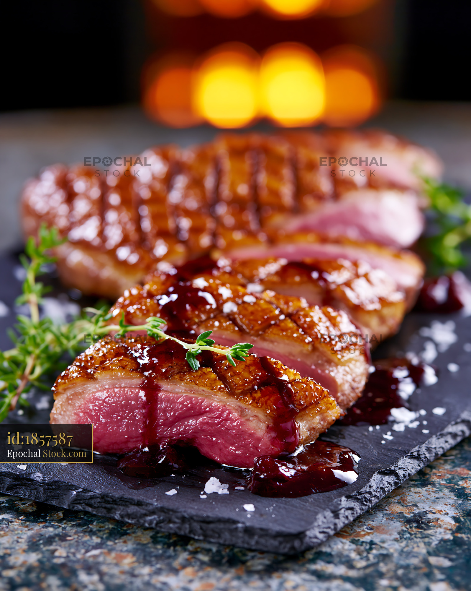 Sliced roasted magret de canard meat with berry sauce and fresh thyme - stock photo