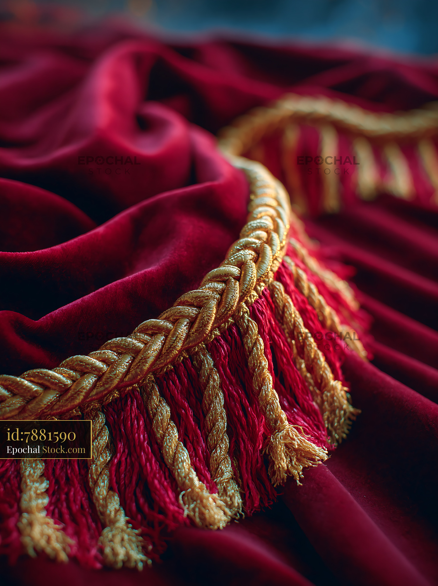 Ornate red velvet stage curtain with decorative gold fringe and tassel