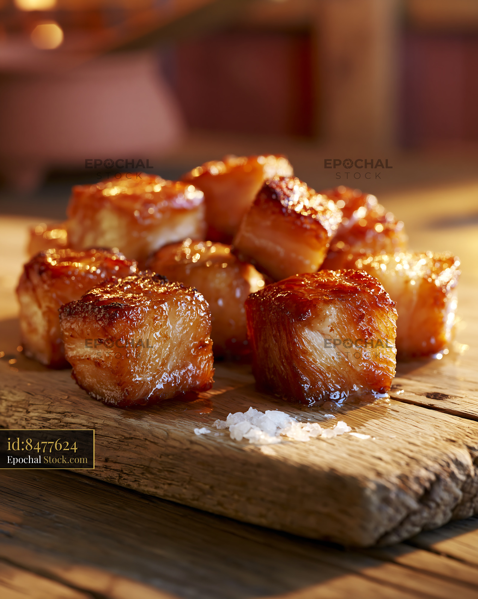 Crispy glazed rillons de tours meat cubes on a rustic wooden board - stock photo