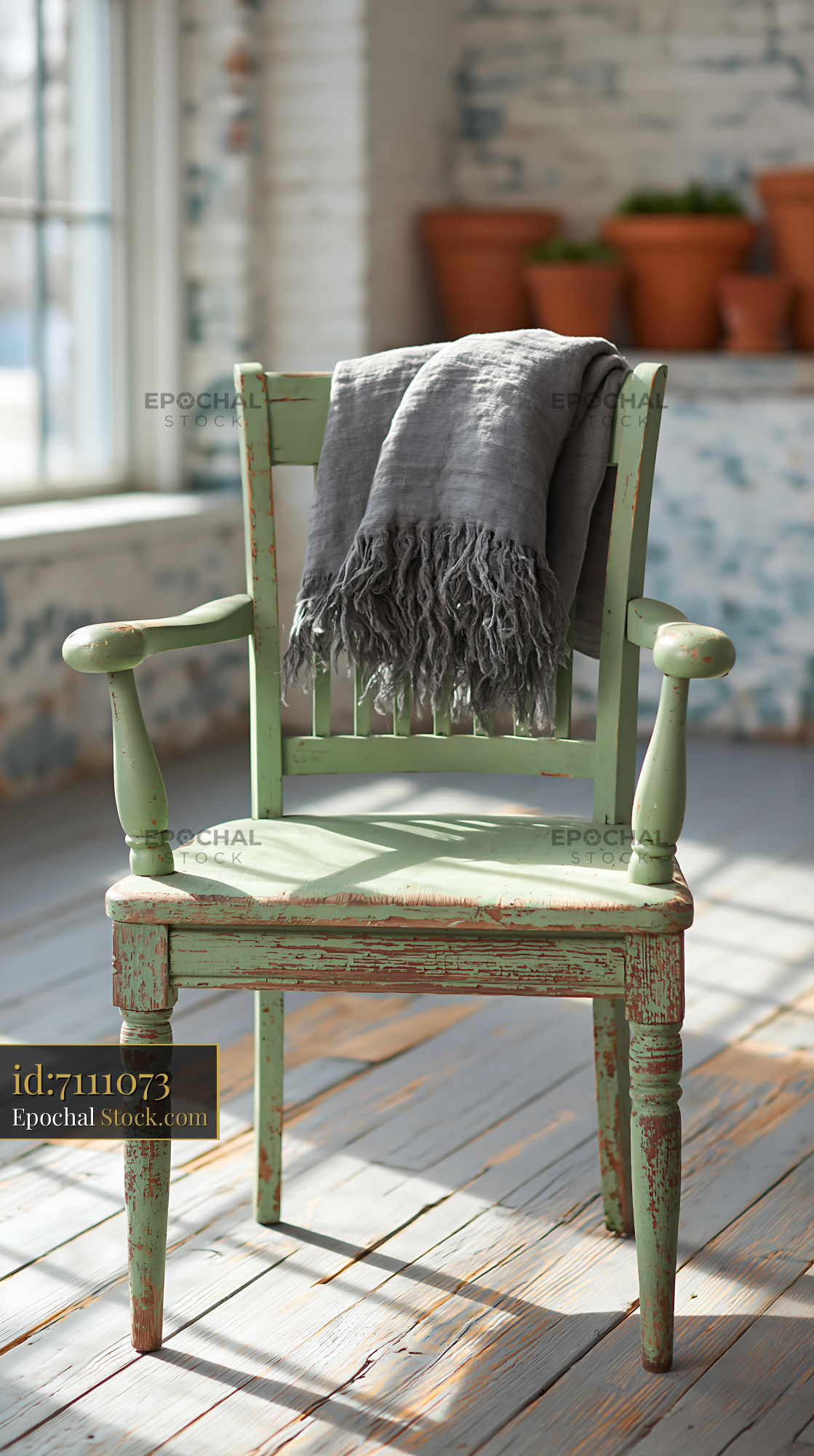 Vintage green wooden chair with grey throw blanket in sunlit room - stock photo