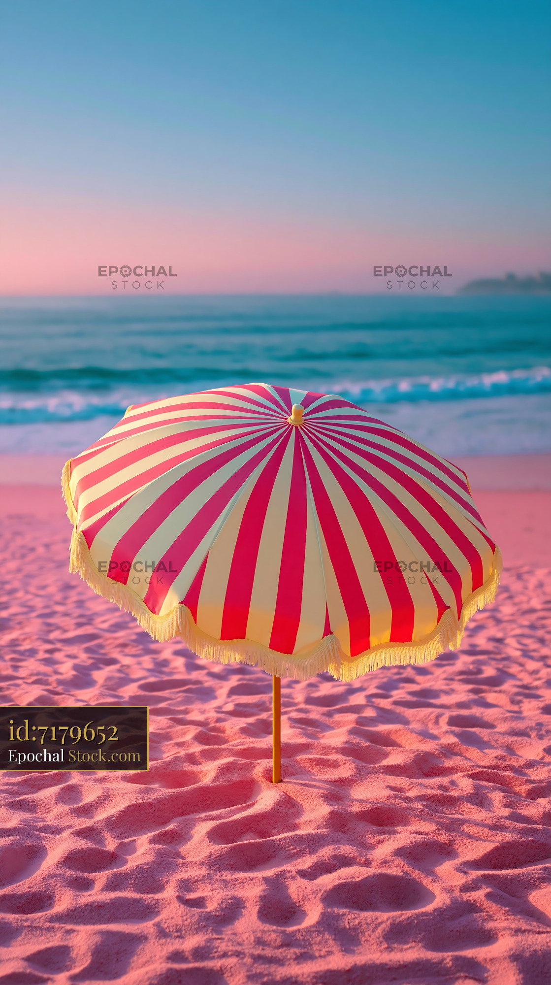 Vintage striped beach umbrella on pink sand at sunset - stock photo