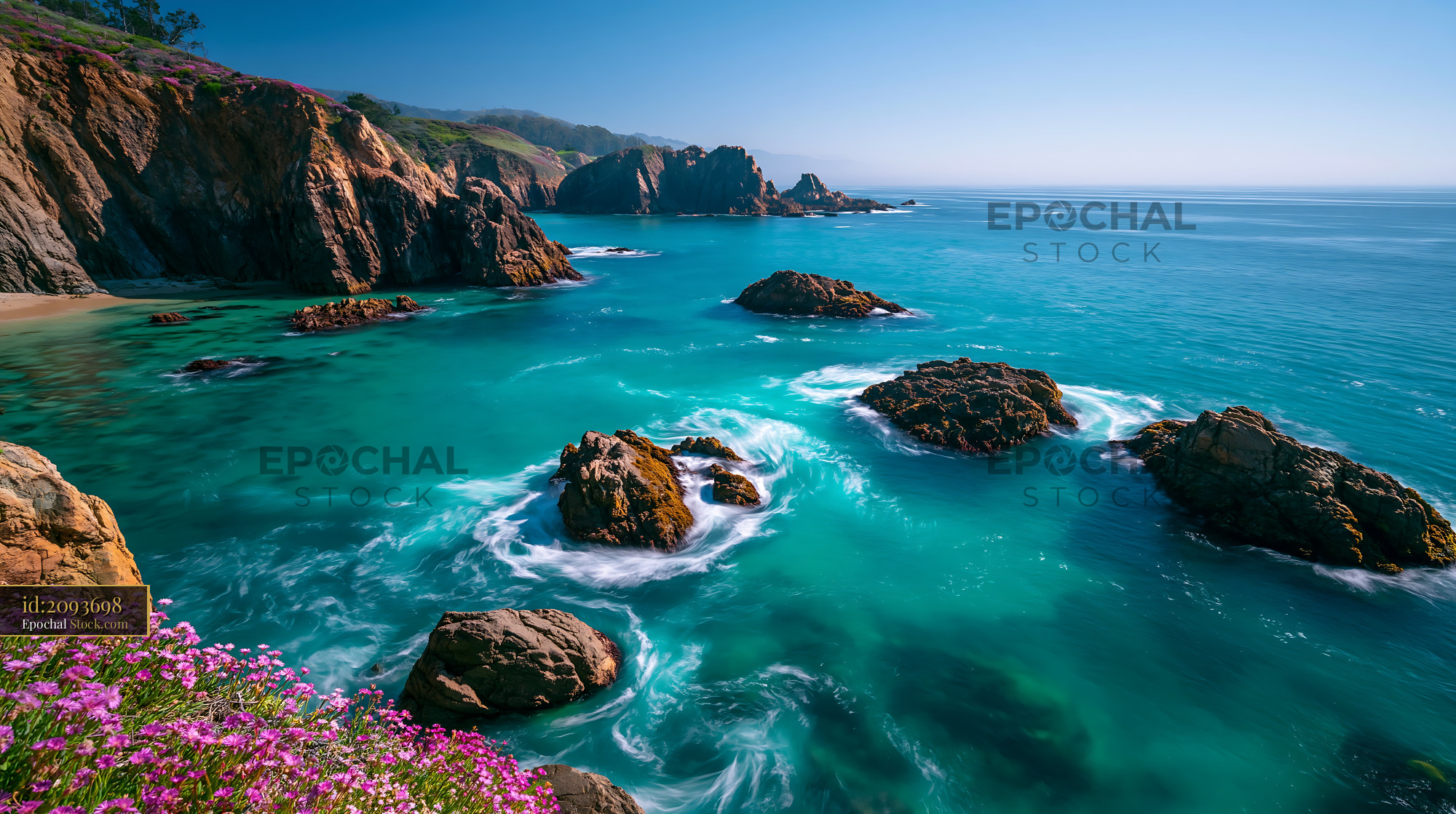Rugged coastline with turquoise waves swirling around rocks and pink f - stock photo