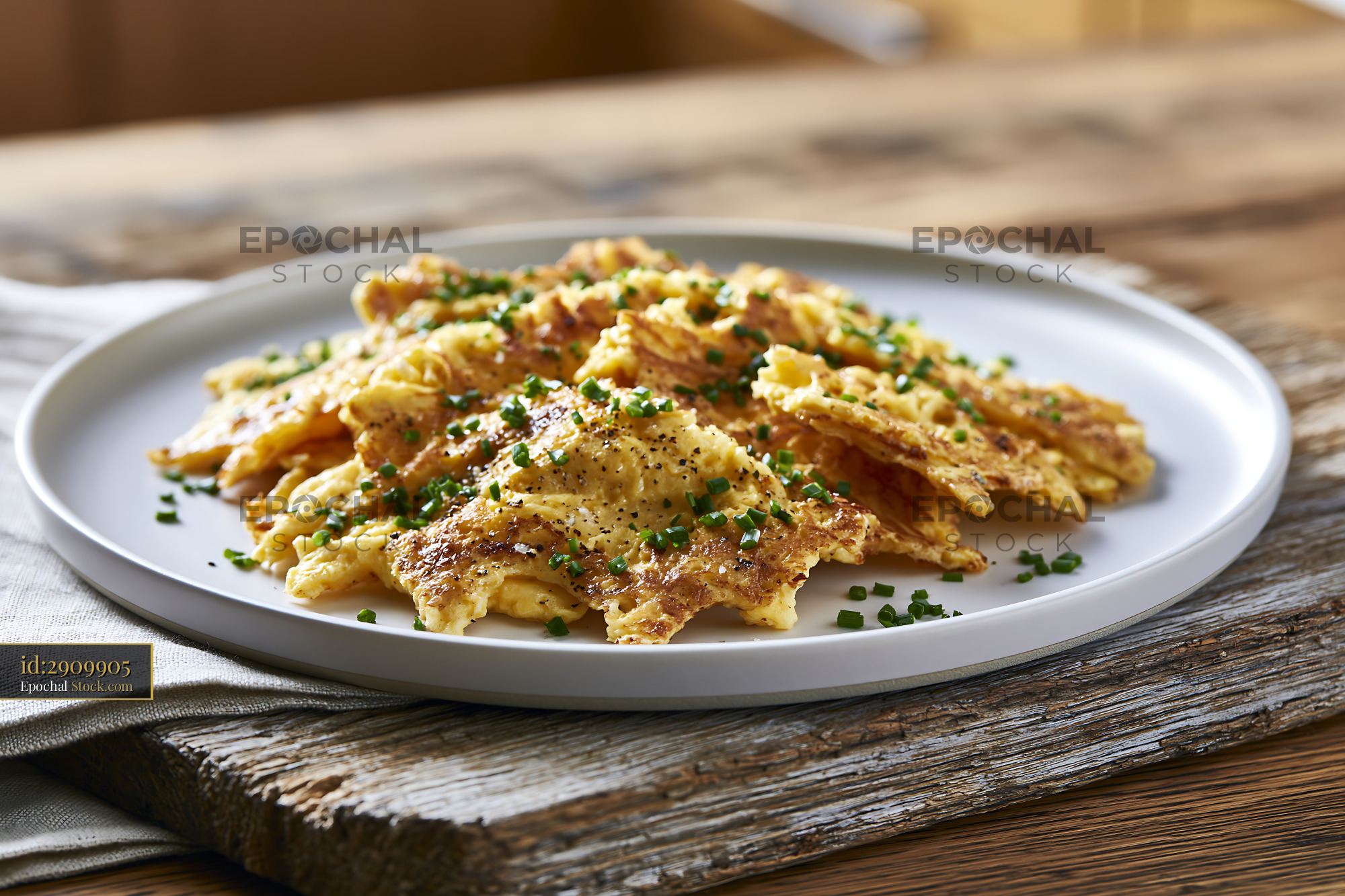 Traditional matzah brei egg food with chives on a rustic wooden table - stock photo