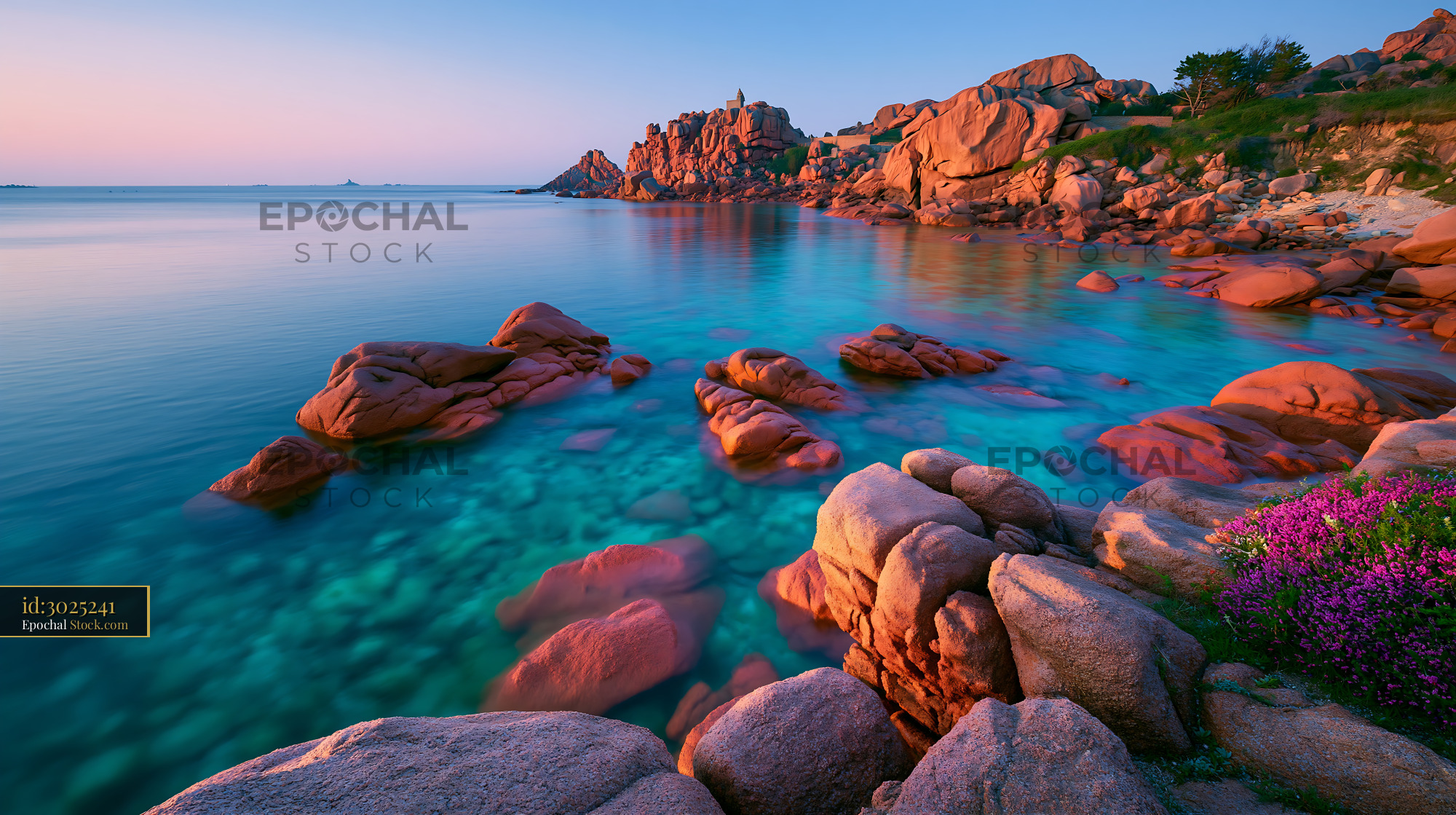 Pink granite rocks and turquoise water at sunset on a distant atoll - stock photo