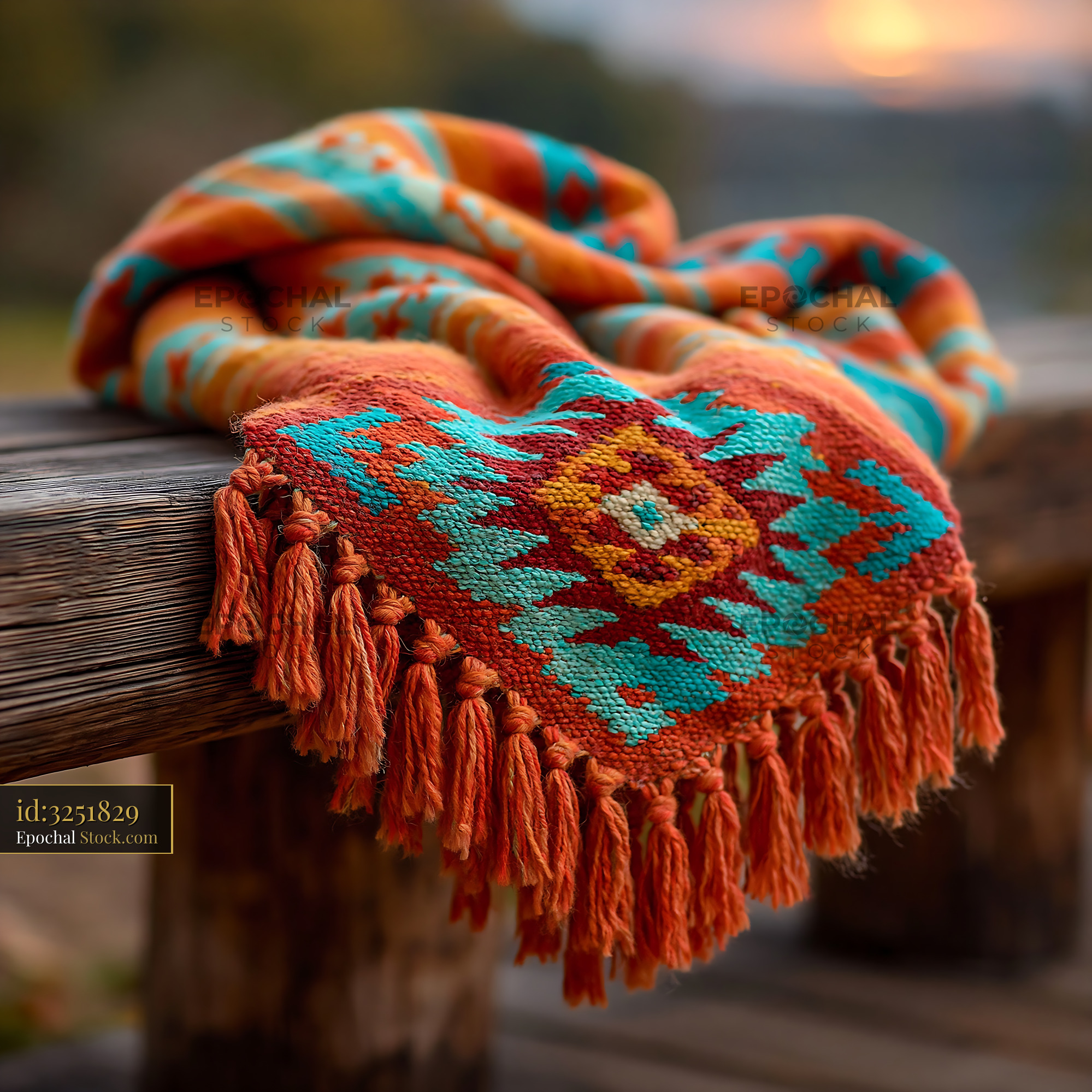 Colorful striped throw on rustic wooden bench during golden hour