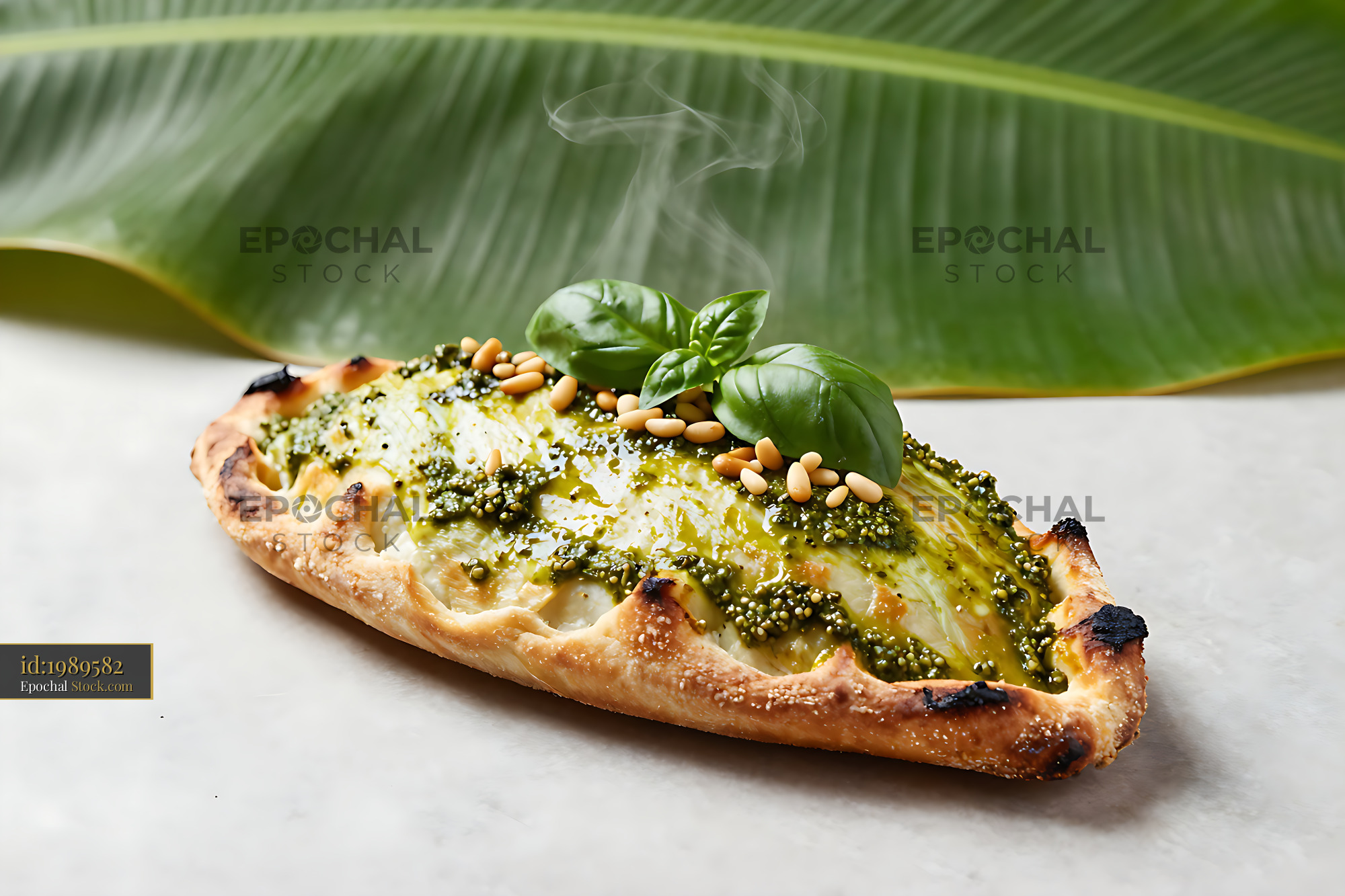 Freshly baked calzone genovese with pesto and pine nut topping - stock photo