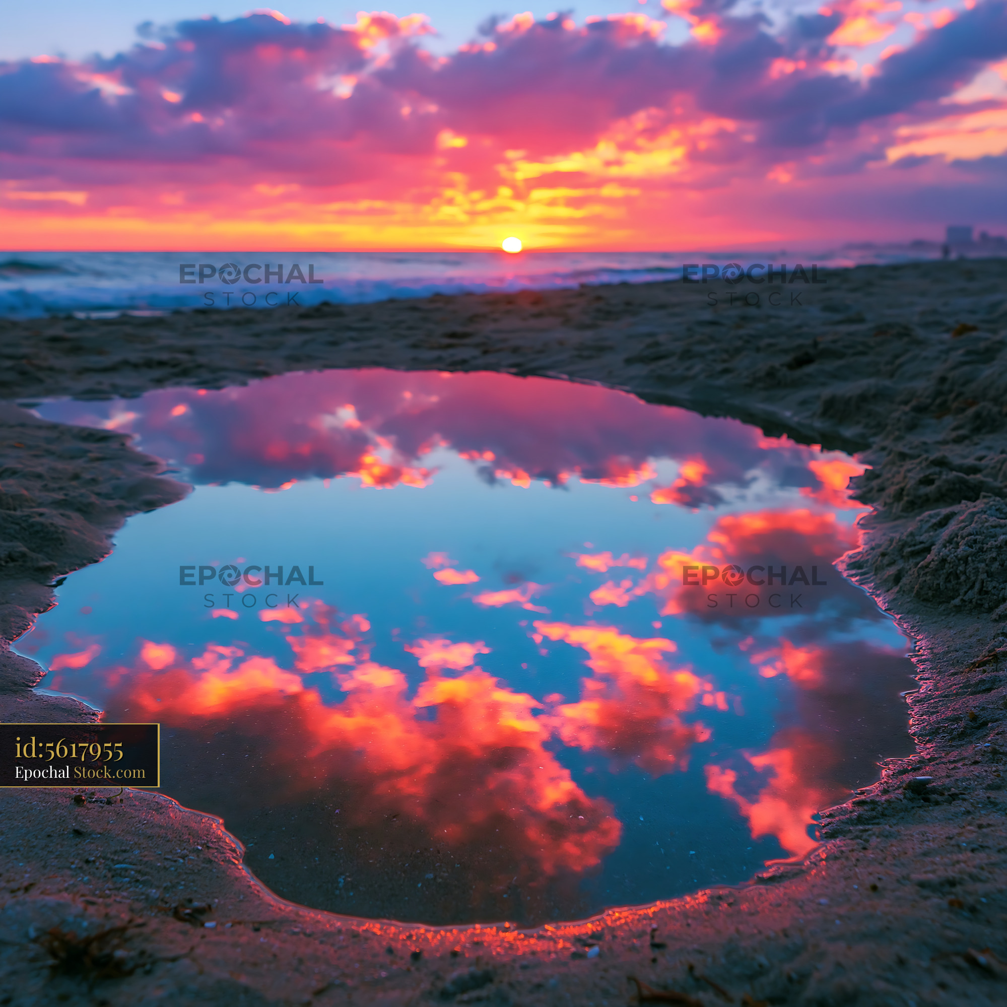Sunset reflection pool on a sandy beach under a vibrant pink sky - stock photo