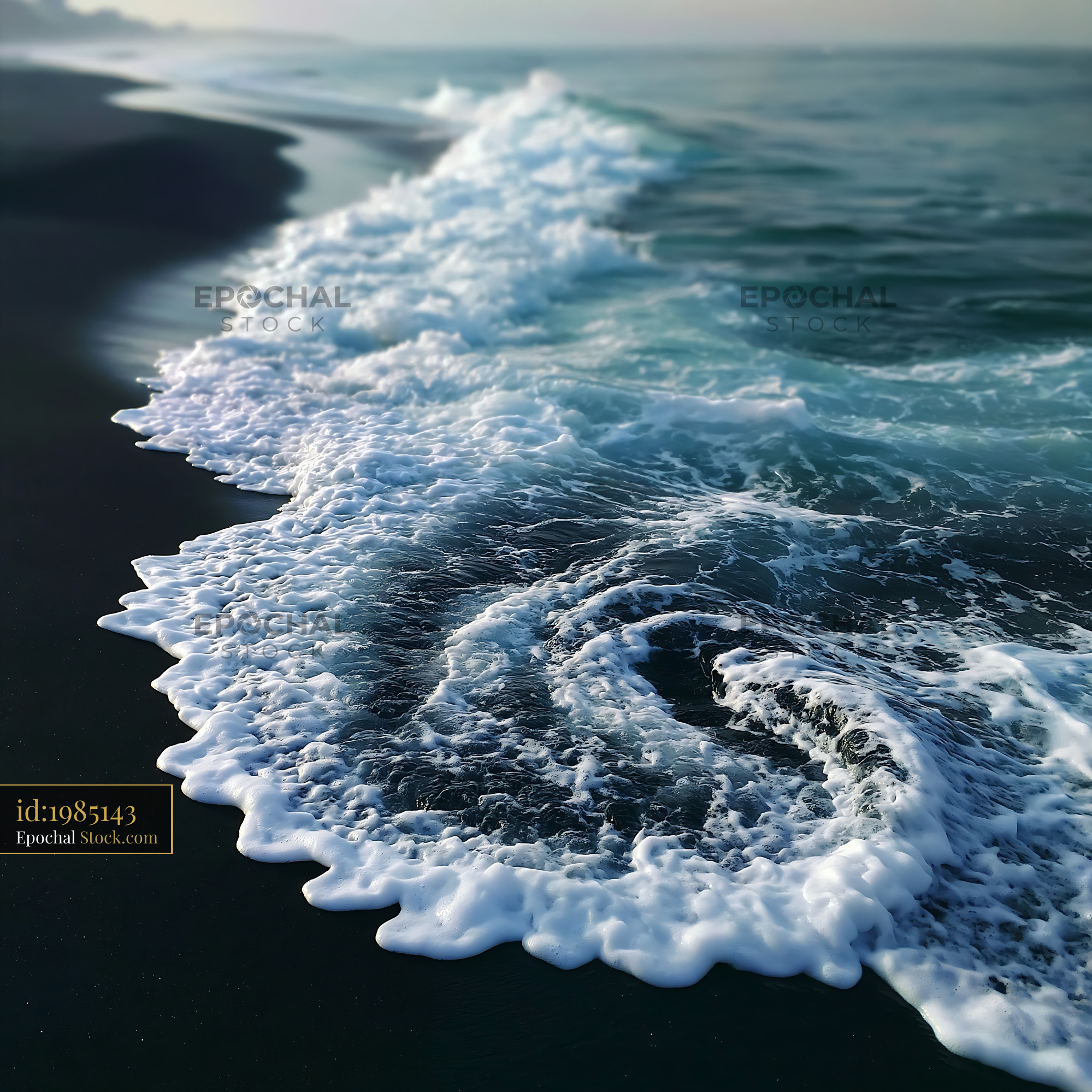 White sea foam swirling on a dark volcanic beach at sunrise - stock photo