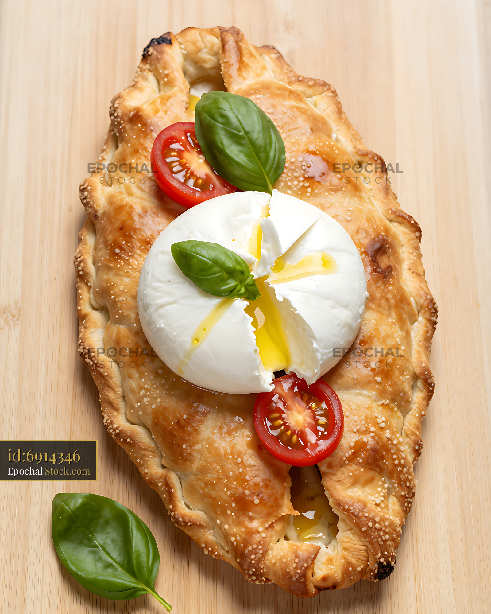 Calzone Pugliese with Burrata Crown topped with fresh basil and tomato - stock photo