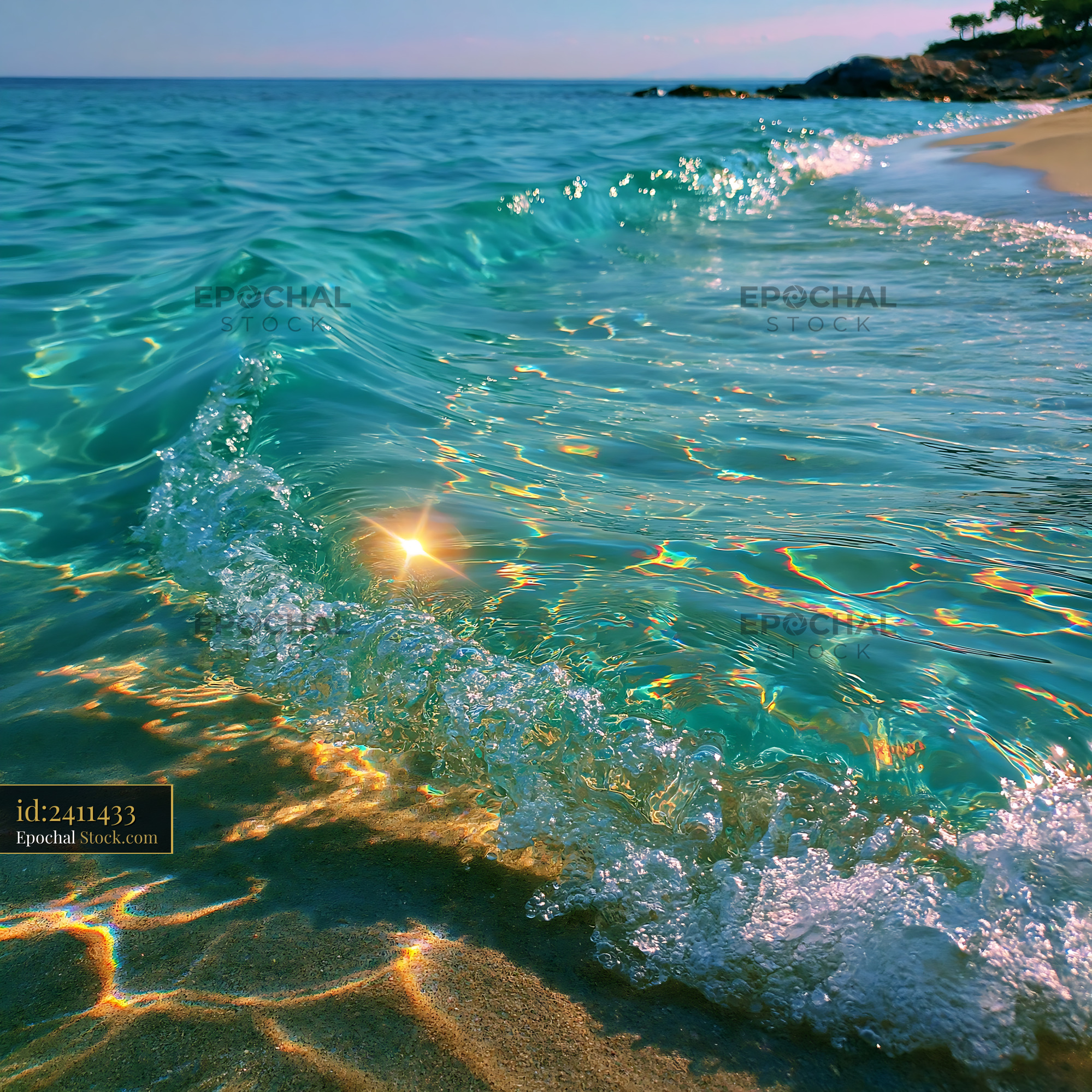 Clear turquoise wave rolling onto a sandy beach with sun flare - stock photo