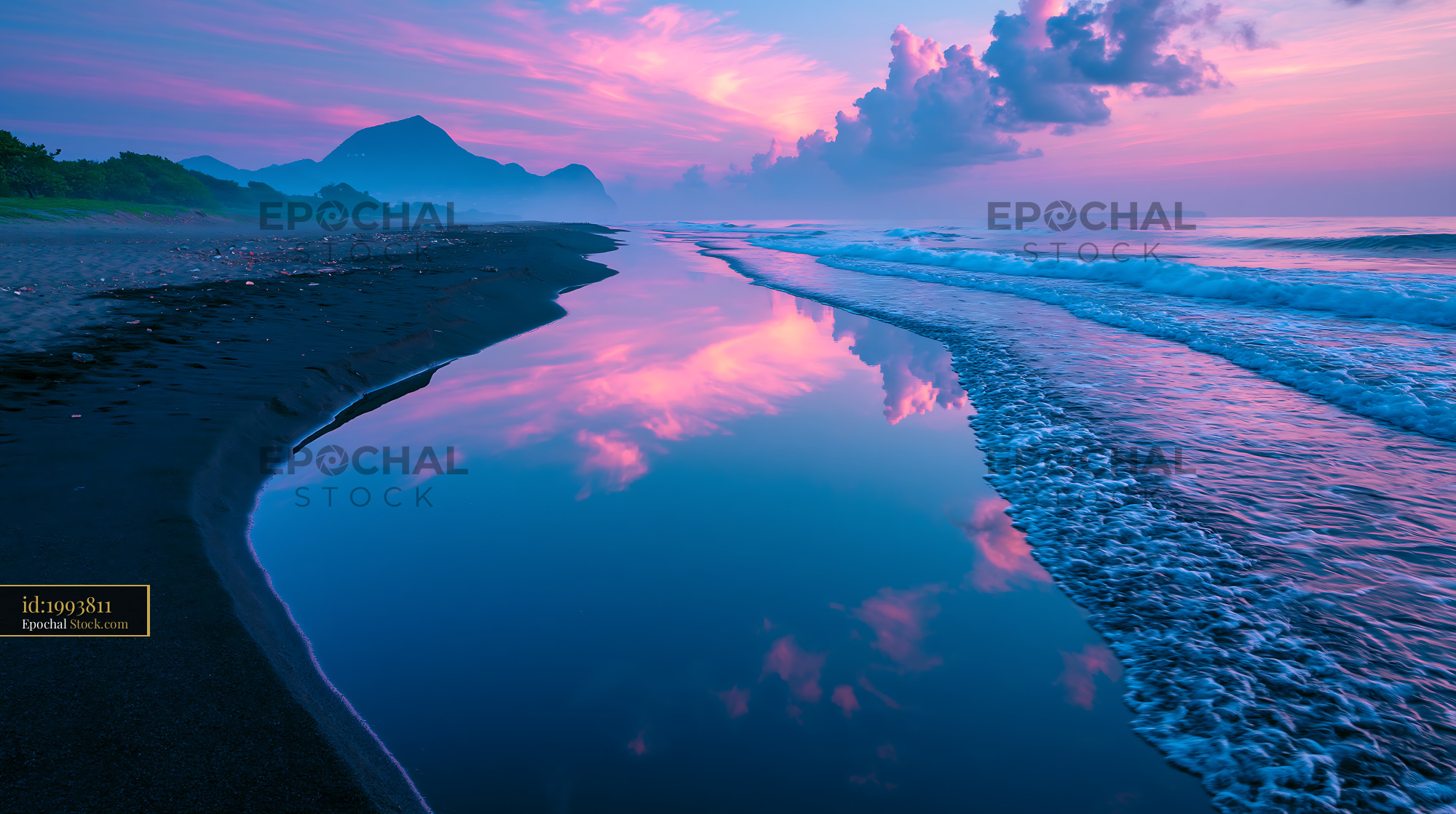 Vibrant pink sunrise reflecting on black sand beach with mountains - stock photo