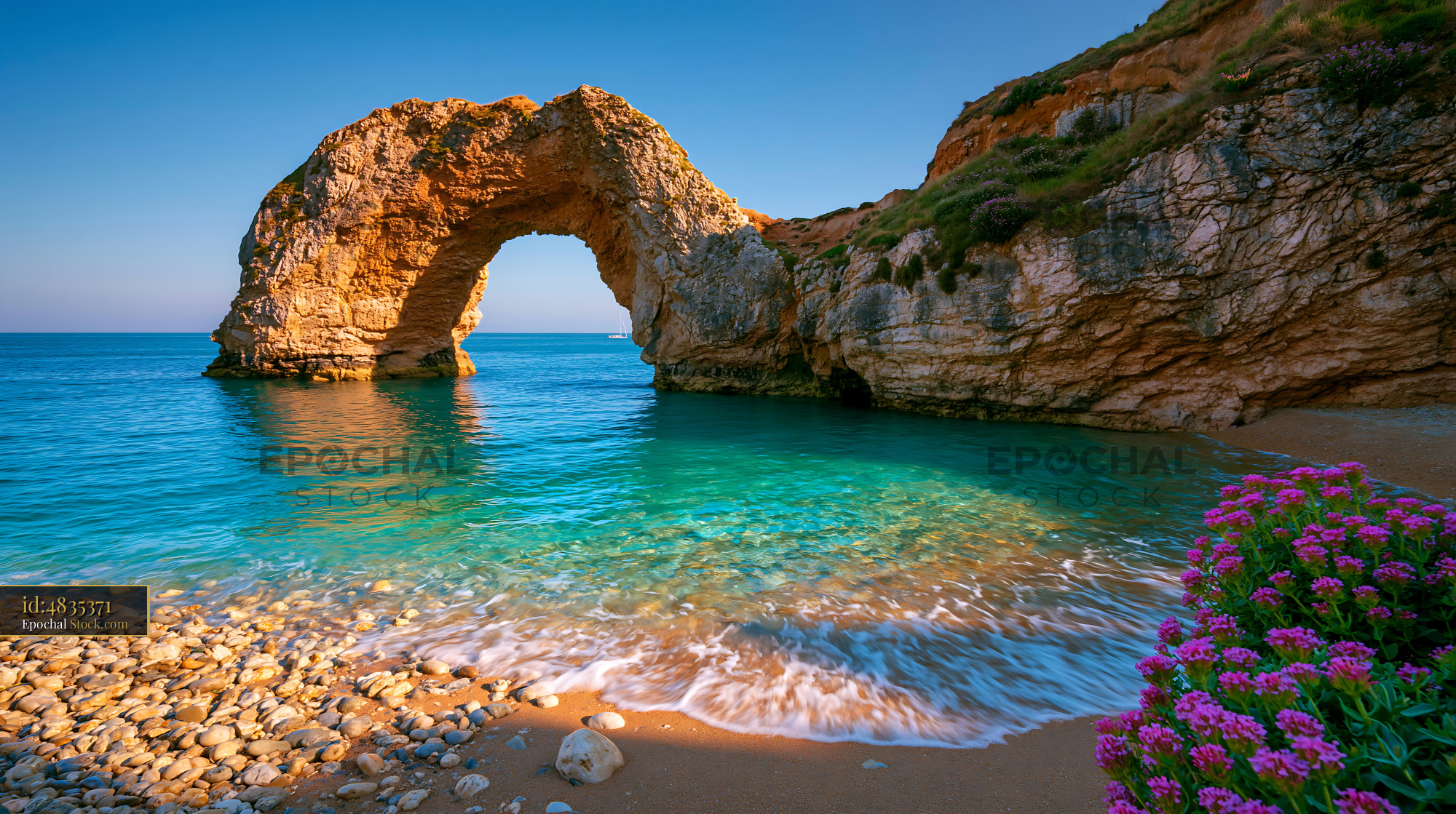 Natural limestone arch at Durdle Door with turquoise water - stock photo