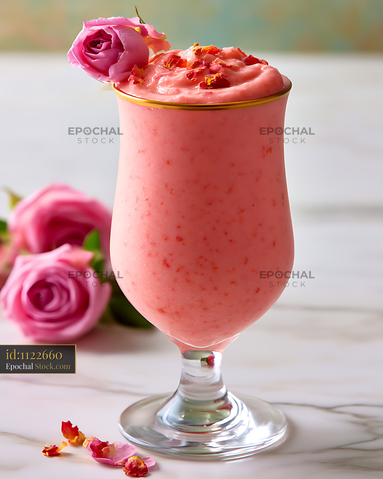 Rose gold smoothie with pink flower garnish on white marble surface - stock photo