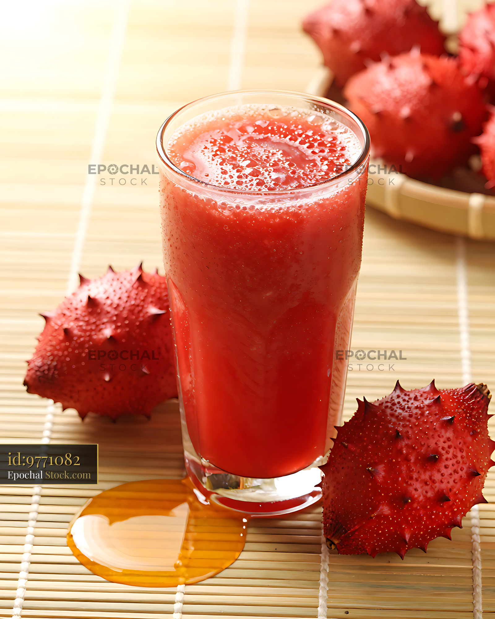 Fresh red gac garden smoothie with honey on a bamboo mat - stock photo