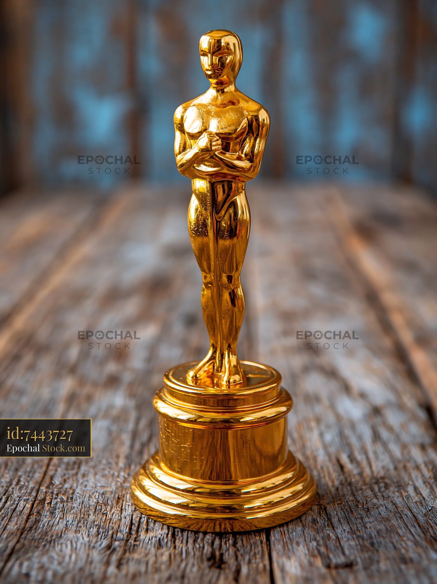 Golden movie award trophy on a rustic wooden surface - stock photo