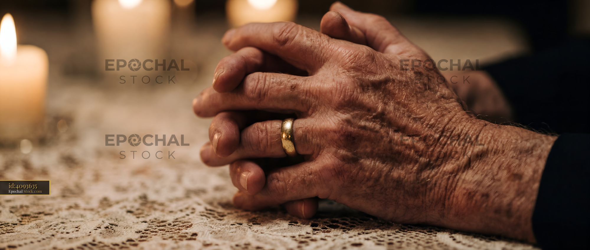 Hands resting on a table near candles in a dim room Premium Stock Photo - stock photo