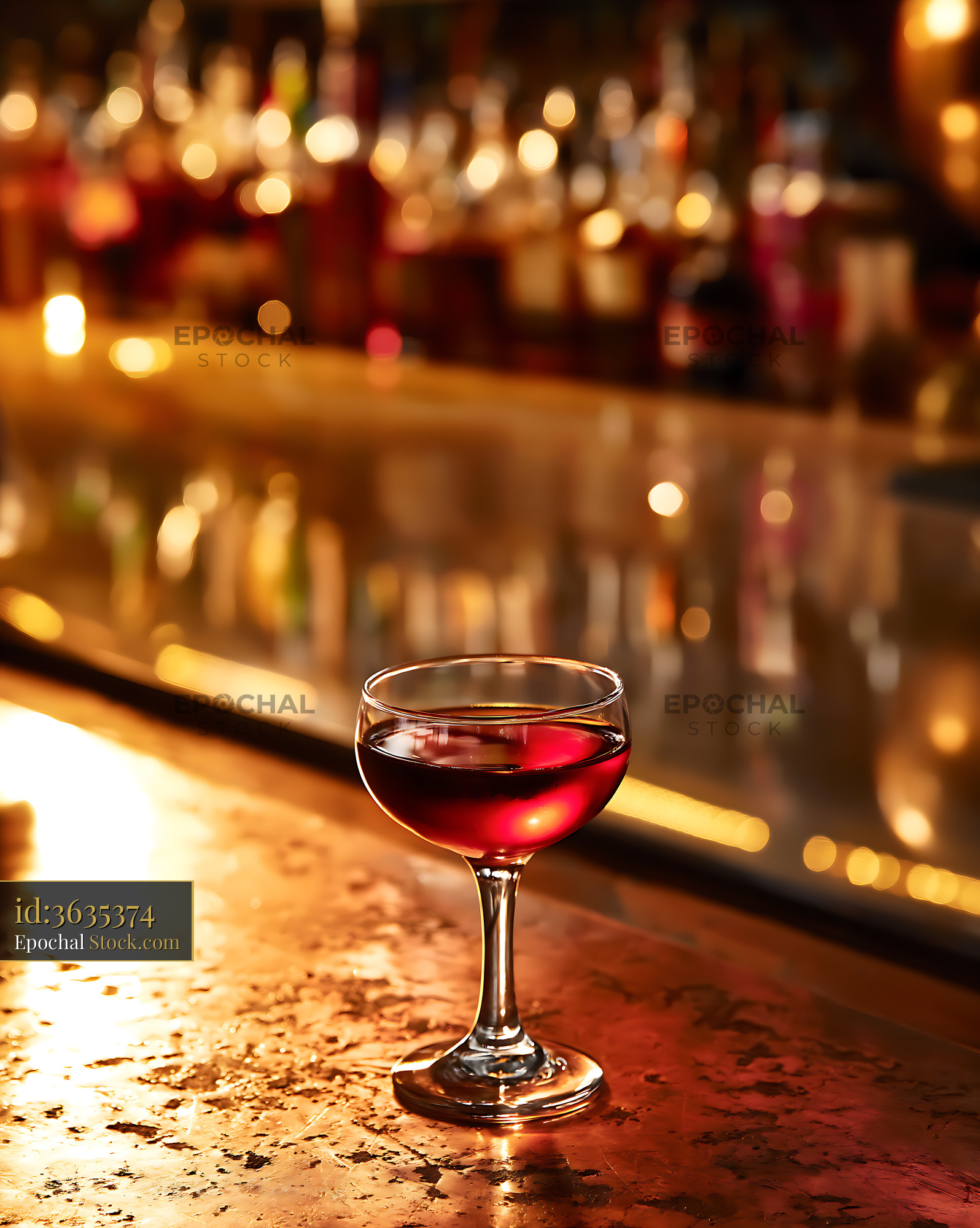 Red Wine Glass at Dimly Lit Bar Counter - stock photo