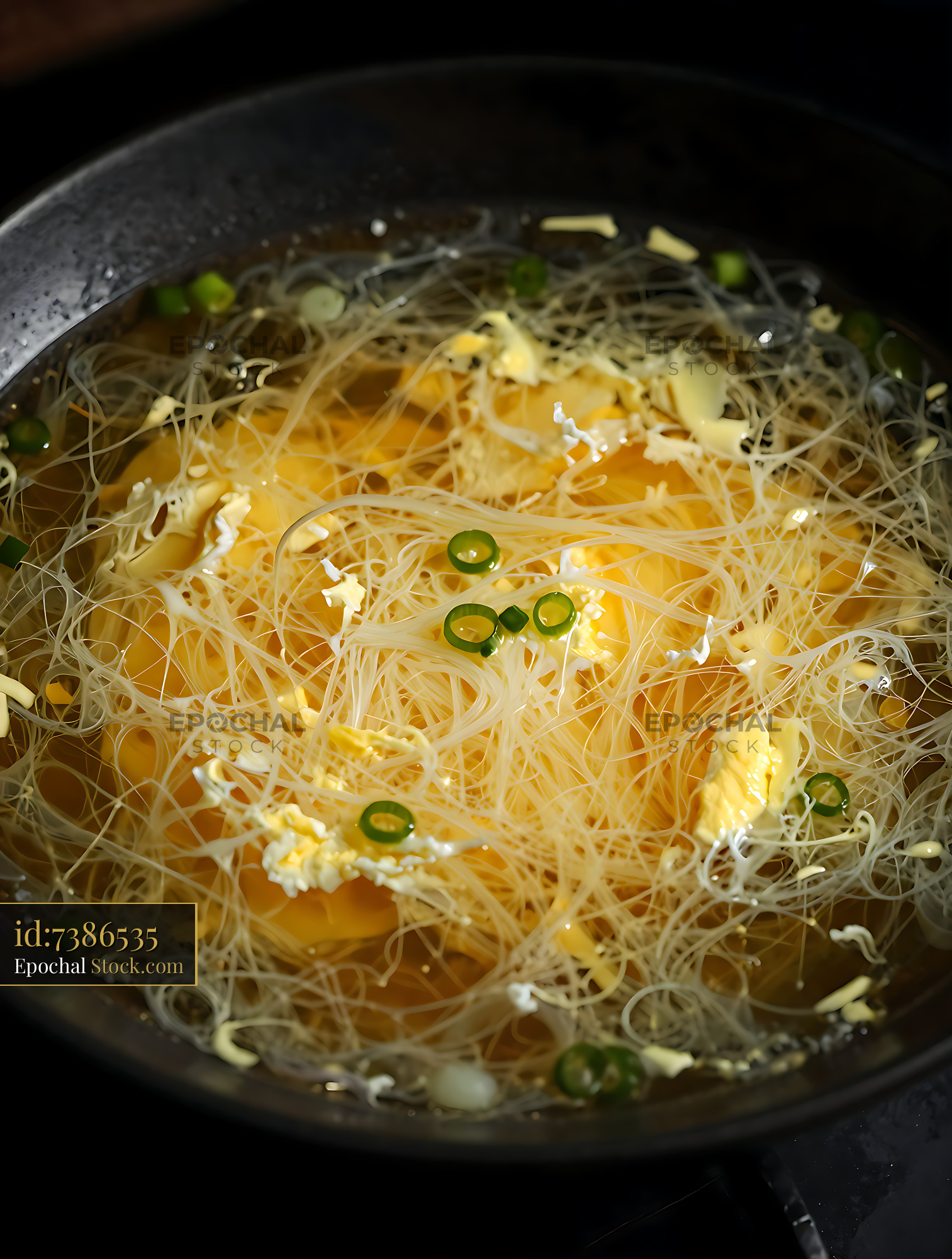 Asian Rice Noodles Cooking in Wok with Onions - stock photo
