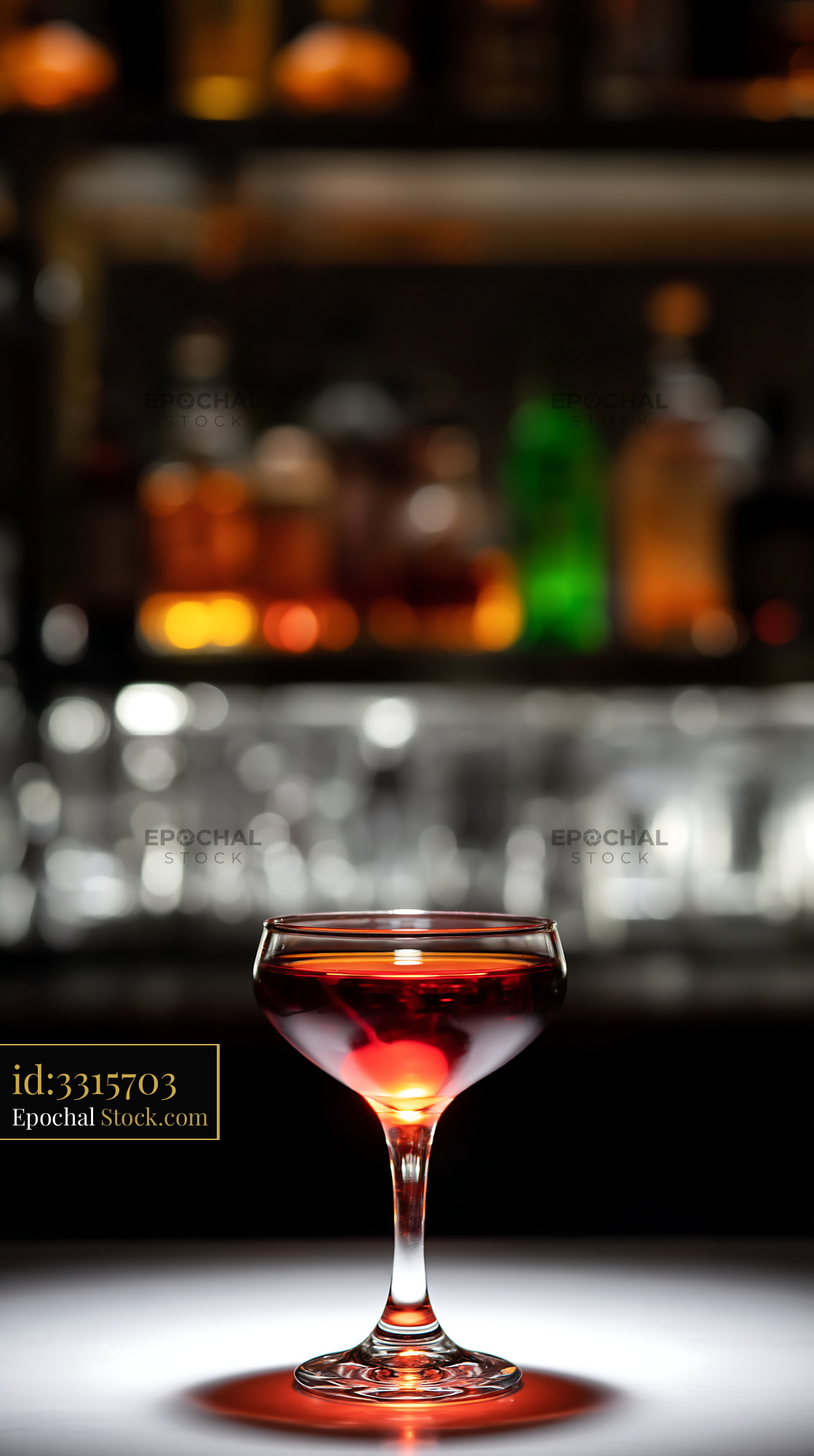 Red Cocktail with Cherry Garnish Behind Bar - stock photo