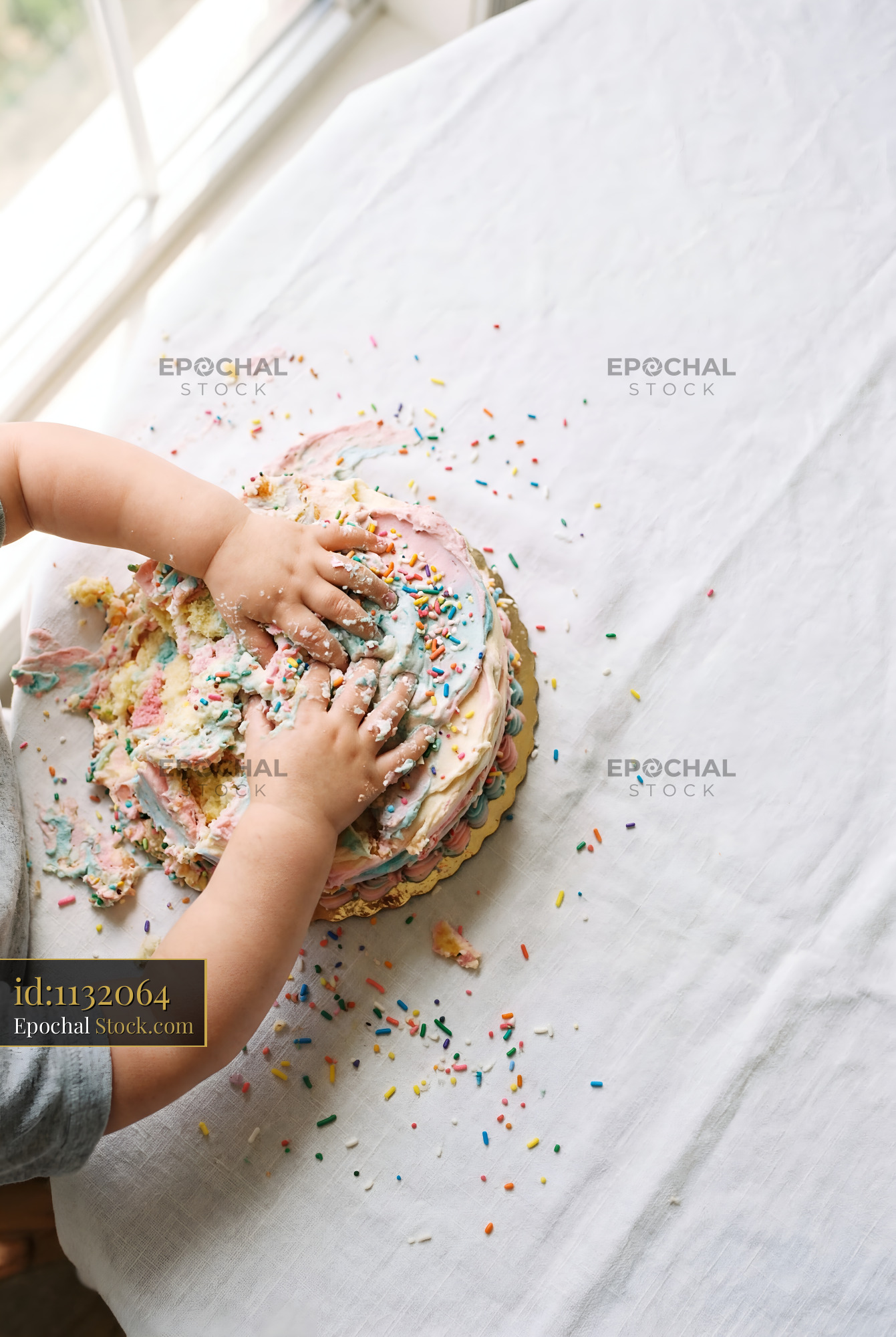 Child plays with cake on a table in bright room Premium Stock Image - stock photo