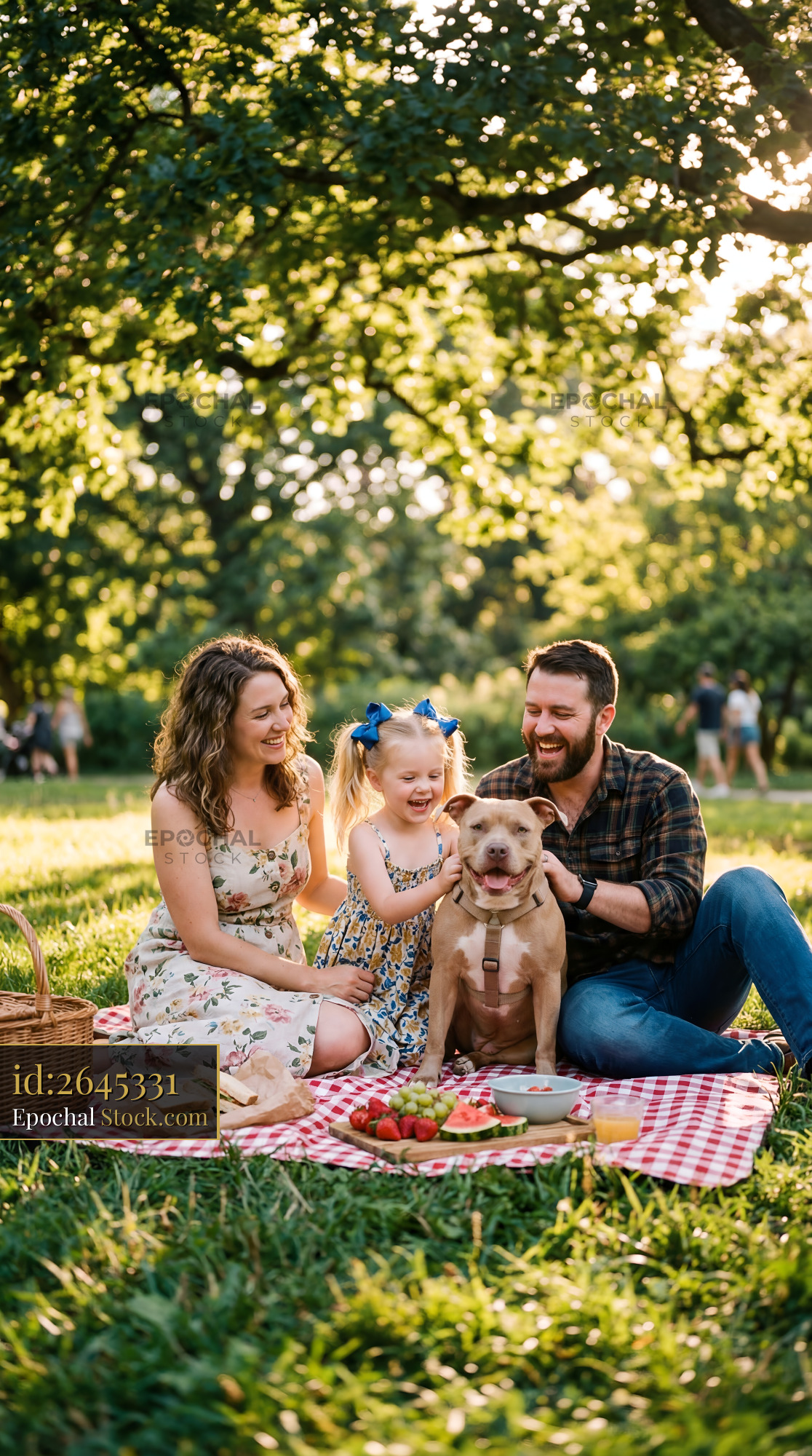 Family enjoys picnic with dog in park on sunny afternoon Premium Stock Photo - stock photo