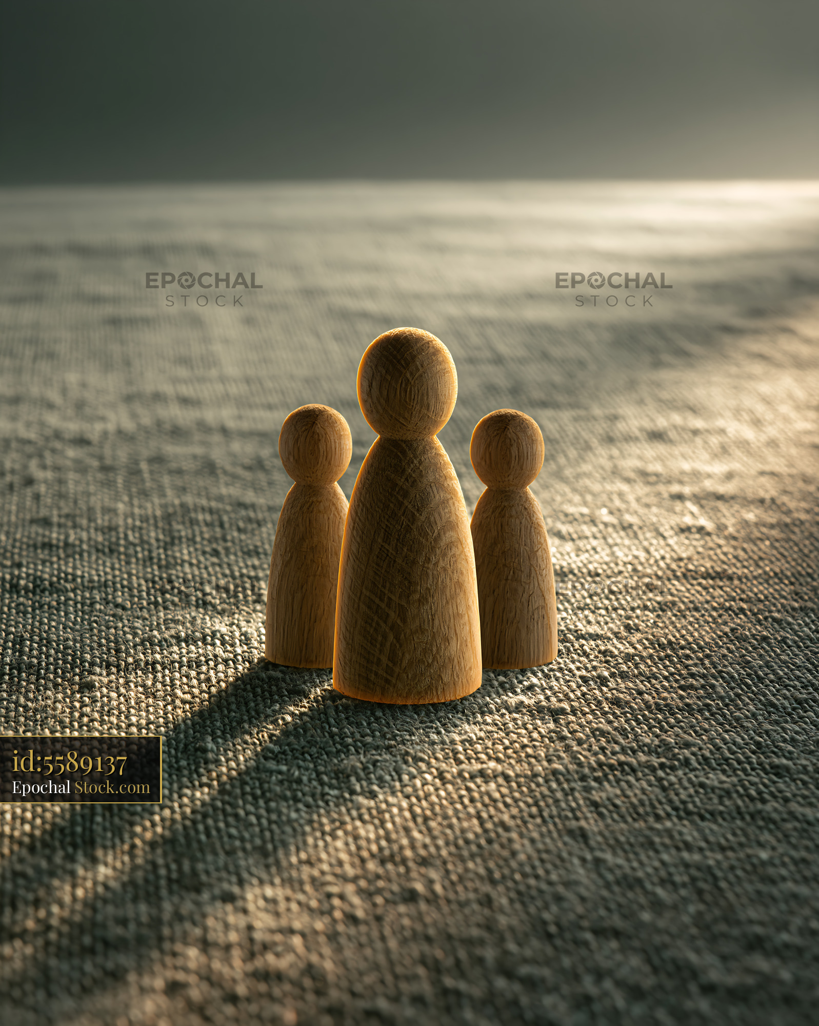 Minimalist wooden family figures standing on textured fabric - stock photo