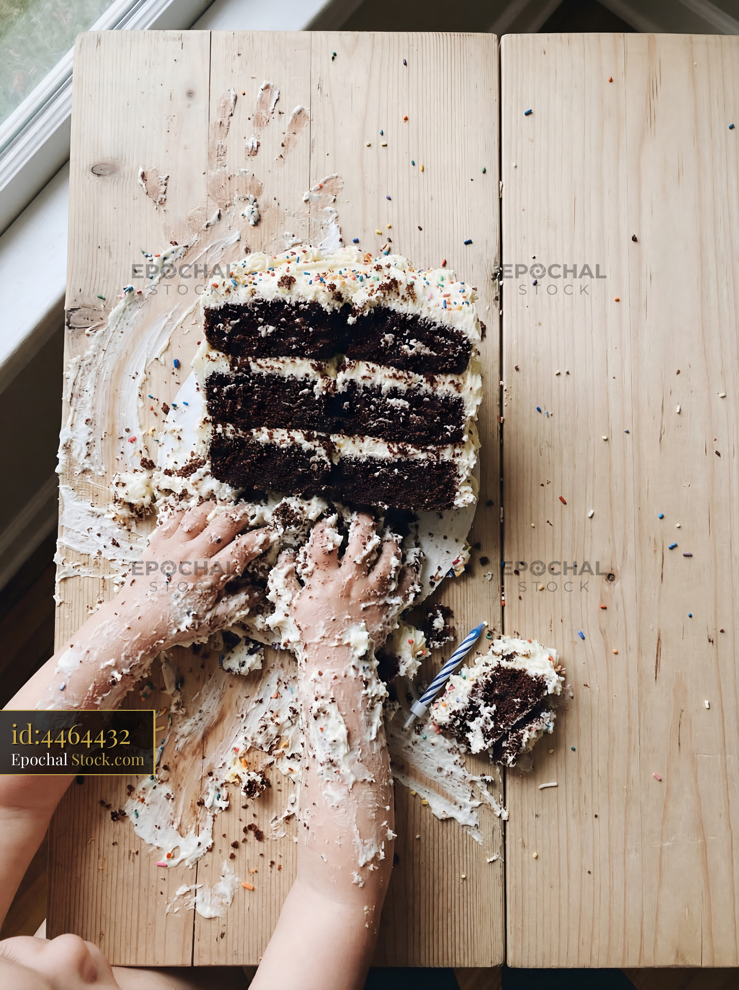 Child enjoys cake with hands at home on a wooden table Premium Stock Photo - stock photo
